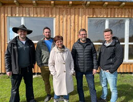 Eine Gruppe von Lehrern, Leitern und die Bürgermeisterin von Wilhelmdorf vor dem Außenklassenzimmer „Beachclub“